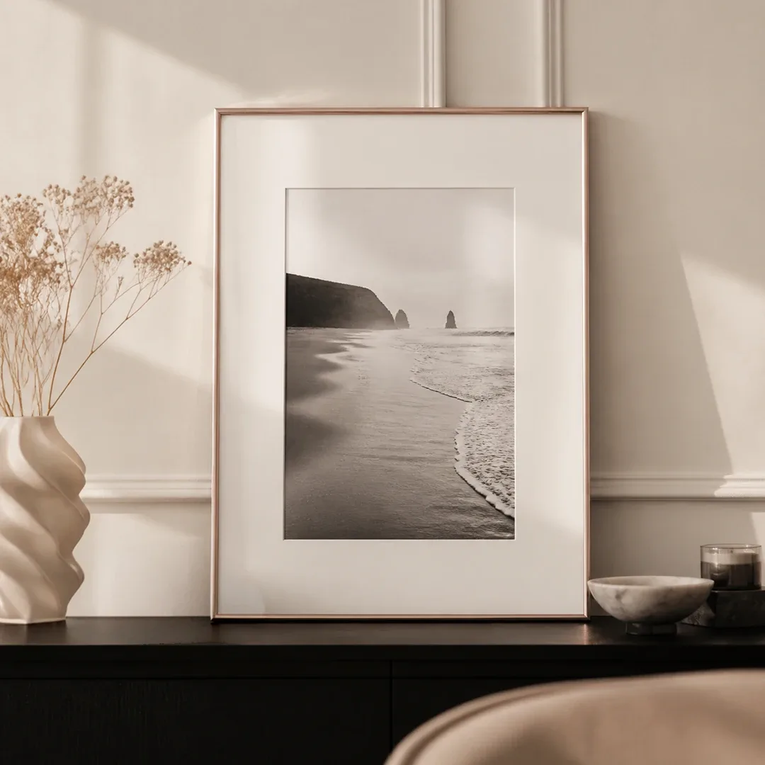 Cadre blanc en plastique avec photo de plage en noir et blanc et passe-partout sur une commode