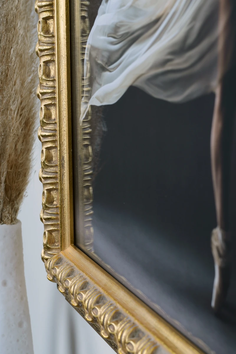 Admire le cadre photo Victoria en bois doré, capturé en gros plan dans un intérieur élégant. Imagine-le embellir ton salon avec MonCadrePréféré.
