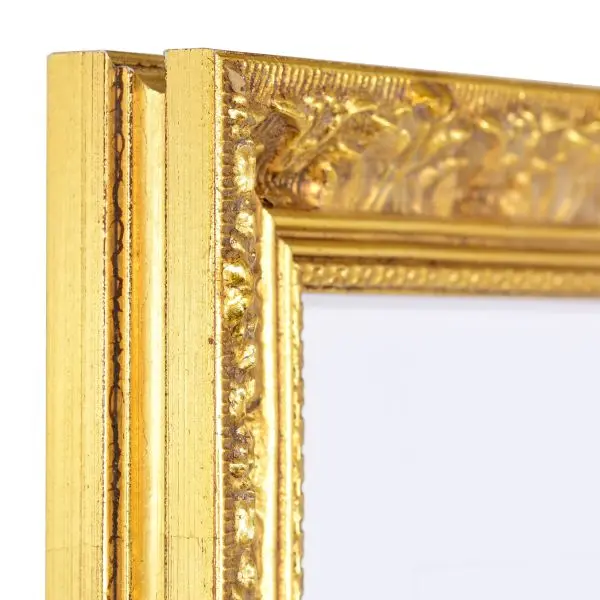 Vue de l'angle d'un cadre en bois de style baroque, avec de fins ornements floraux et son éclat doré brillant.