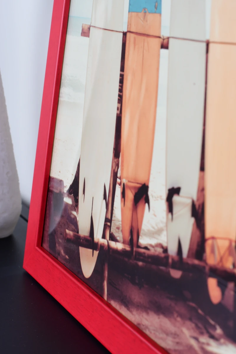 Admire le cadre photo Emma en bois rouge de MonCadrePréféré. Ce gros plan révèle l'élégance de ce cadre dans ton salon moderne.
