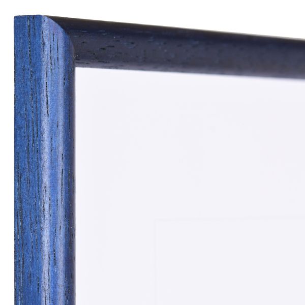 L'angle d'un cadre classique en bois bleu, à pores ouverts, avec un profilé demi-rond fin. Une pièce MonCadrePréféré.