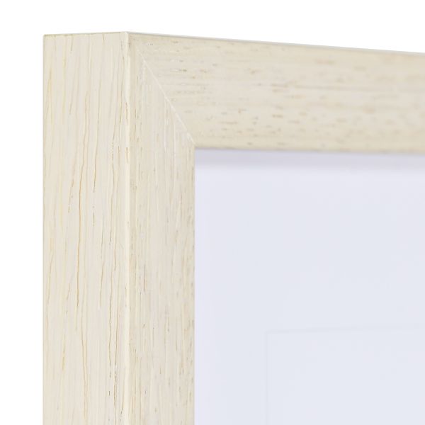 Vue de l'angle d'un cadre photo carré, moderne, en bois blanc. La structure naturelle du bois est visible chez MonCadrePréféré.