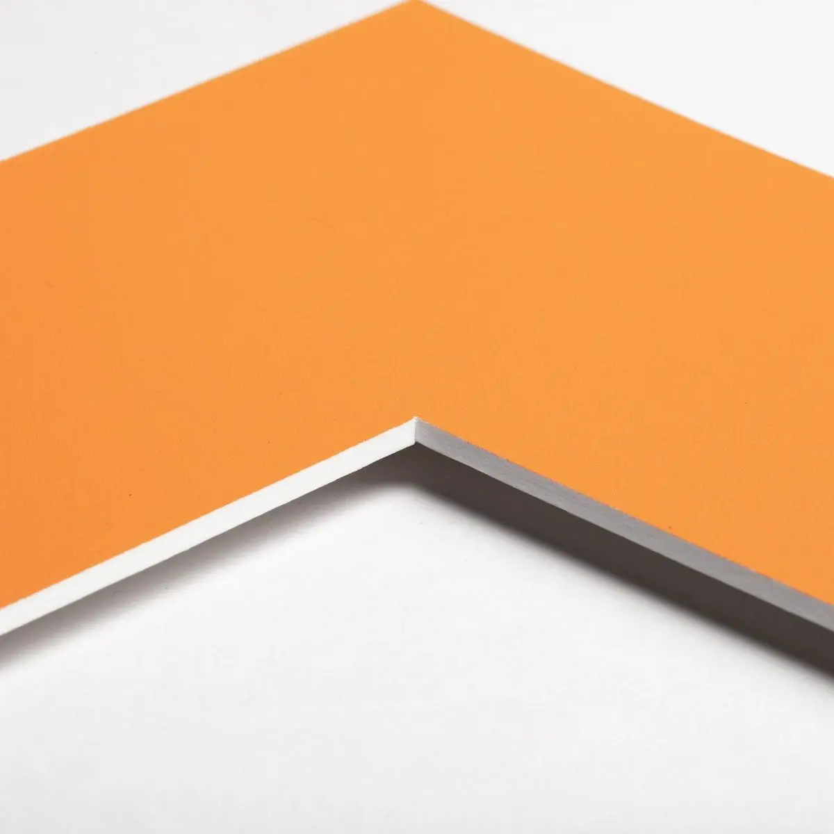 Découvre le coin d'un passe-partout de couleur orange vif, un accessoire essentiel pour tes cadres photo MonCadrePréféré.