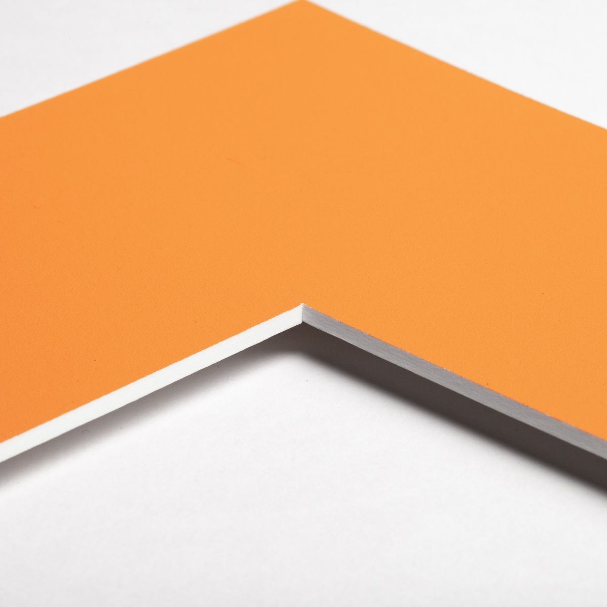 Découvre le coin d'un passe-partout de couleur orange vif, un accessoire essentiel pour tes cadres photo MonCadrePréféré.