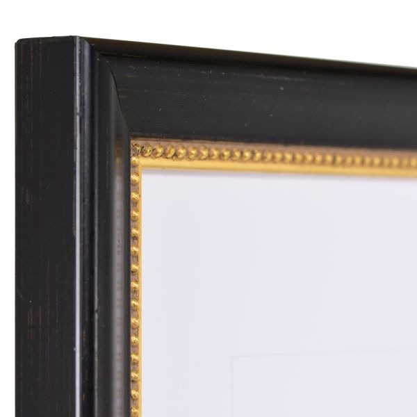 Admire l'angle de ce cadre en bois noir, avec son métal brossé main et sa moulure perlée sur le bord intérieur.